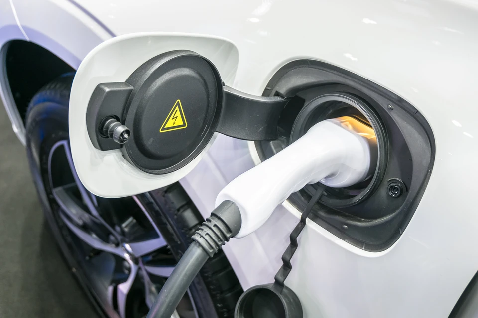 Scène extérieure montrant la recharge d'un véhicule électrique blanc