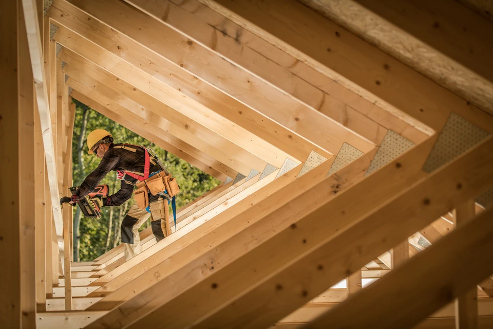 Professionnel qualifié en gilet de sécurité et casque blanc inspectant l'installation de panneaux solaires photovoltaïques sur une toiture résidentielle, effectuant un contrôle de qualité ou un diagnostic avec un équipement de mesure professionnel, sous un ciel ensoleillé, illustrant un accompagnement technique sur mesure du bilan au résultat final.